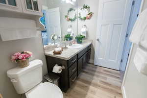 Bathroom featuring vanity, wood-type flooring, and toilet