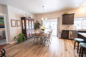 Dining room featuring a chandelier, light hardwood / wood-style flooring, plenty of natural light, and sink