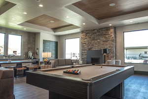 Recreation room featuring a raised ceiling, billiards, a fireplace, wood ceiling, and hardwood / wood-style flooring