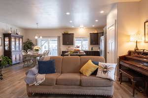 Living room with sink, a notable chandelier, and light wood-type flooring