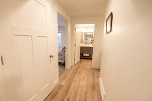 Corridor with light hardwood / wood-style flooring