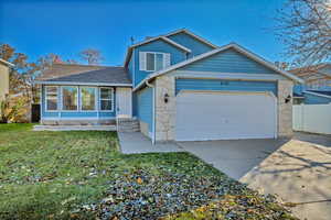 View of front of home with a garage and a front lawn