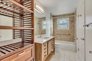 Full bathroom with tile patterned floors, vanity, toilet, and tiled shower / bath