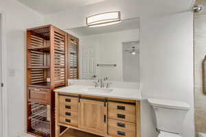 Bathroom with ceiling fan, toilet, and vanity