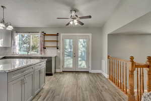 Kitchen featuring gray cabinets, a wealth of natural light, French doors, and tile flooring