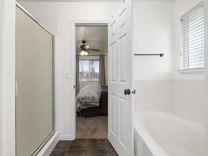 Bathroom with tile patterned floors, ceiling fan, and shower with separate bathtub