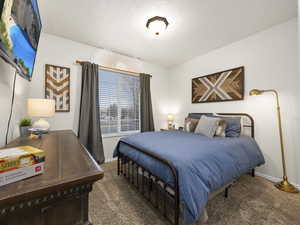 Bedroom featuring a textured ceiling and carpet floors