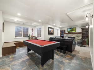 Rec room with a stone fireplace and pool table