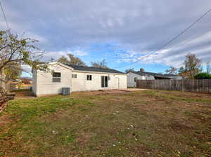 Back of house with a lawn, central AC, and a patio area