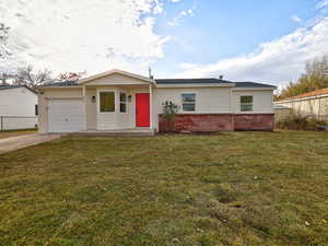 Ranch-style house with a garage and a front lawn