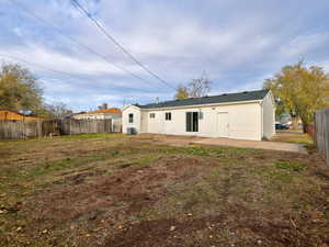 Rear view of house with a yard, a patio area, and central air condition unit