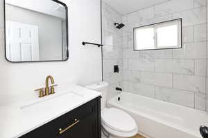 Full bathroom featuring vanity, toilet, and tiled shower / bath