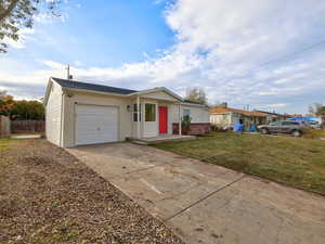 View of front facade featuring a front yard and a garage