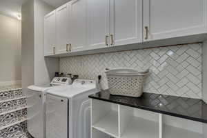 Laundry area with separate washer and dryer, tile patterned flooring, and cabinets