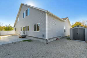 Back of house featuring a patio and a storage unit