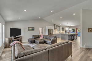 Living room/great room, light hardwood / wood-style flooring, and vaulted ceiling