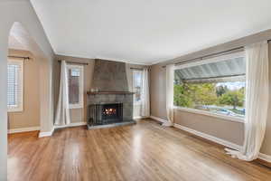 Unfurnished living room with a large fireplace, plenty of natural light, and light hardwood / wood-style flooring