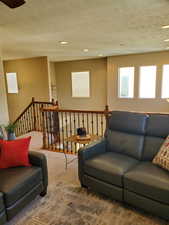 Carpeted living room featuring a textured ceiling