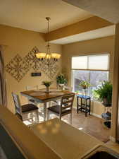 Dining area with carpet and an inviting chandelier