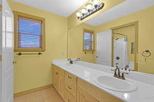 Bathroom featuring tile patterned flooring, vanity, and a shower with shower curtain