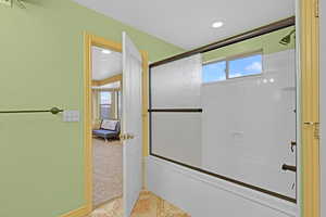 Bathroom featuring enclosed tub / shower combo, tile patterned flooring, and a healthy amount of sunlight