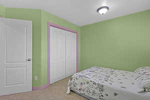 Bedroom featuring a closet, carpet, and a textured ceiling