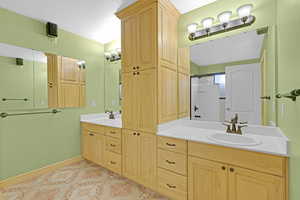 Bathroom featuring a shower with door, vanity, a textured ceiling, and tile patterned flooring