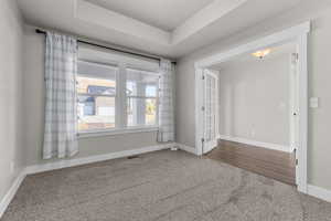 Spare room with wood-type flooring and a tray ceiling