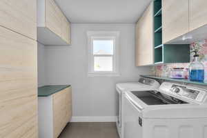 Laundry area featuring cabinets and separate washer and dryer