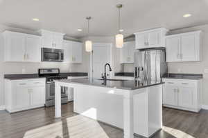 Kitchen with white cabinetry, appliances with stainless steel finishes, and light hardwood / wood-style flooring