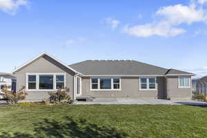 Rear view of house featuring a patio area and a lawn