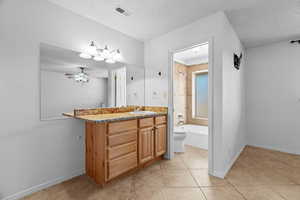 Bathroom with tile patterned floors, ceiling fan, a textured ceiling, and toilet