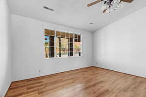 Unfurnished room featuring ceiling fan, light hardwood / wood-style floors, and a textured ceiling