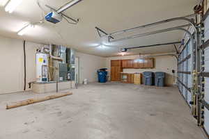 Garage with heating unit, water heater, and a garage door opener