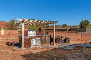 View of yard with a pergola and an outdoor kitchen