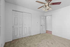 Unfurnished bedroom featuring carpet, a textured ceiling, a closet, and ceiling fan