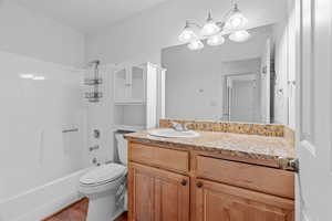 Full bathroom with shower / bath combination, vanity, toilet, and wood-type flooring