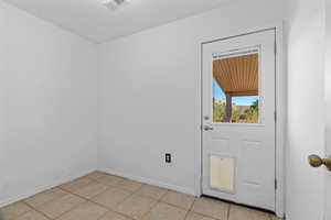 Doorway with light tile patterned floors