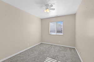 Carpeted empty room featuring ceiling fan