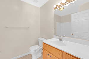 Bathroom featuring tile patterned flooring, vanity, and toilet