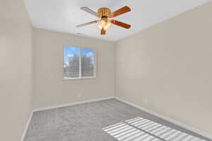 Carpeted empty room with ceiling fan