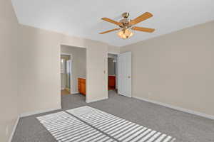 Unfurnished bedroom featuring ceiling fan, light colored carpet, and connected bathroom