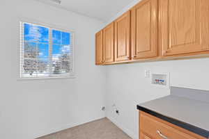 Laundry area featuring washer hookup, hookup for an electric dryer, and cabinets