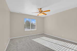 Unfurnished room featuring ceiling fan and light colored carpet