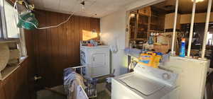 Laundry room with washer and dryer and wooden walls