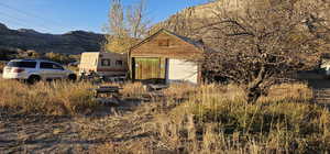 View of side of property featuring a mountain view and an outdoor structure