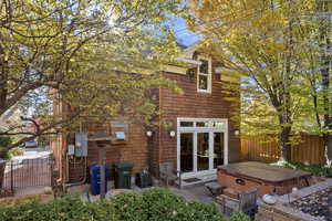 Rear view of property featuring a patio and a hot tub