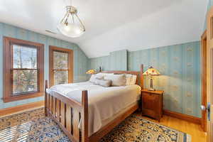 Primary Bedroom featuring light hardwood / wood-style flooring and vaulted ceiling