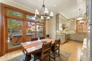 Dining room featuring a wealth of natural light, crown molding, light hardwood / wood-style floors, and a notable chandelier