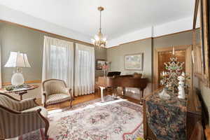 Sitting room featuring wood-type flooring and a notable chandelier